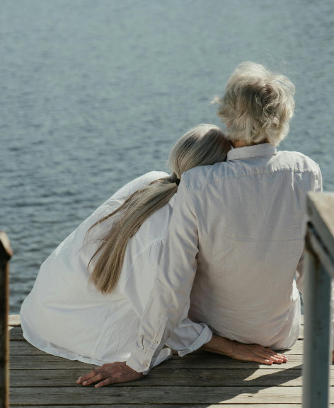 Sad man and woman looking out over the lake.